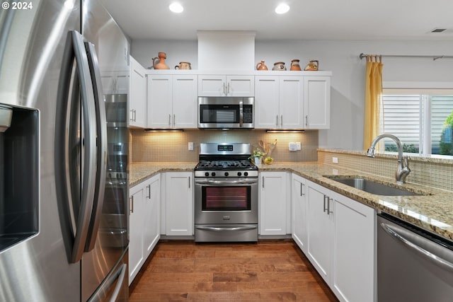 kitchen featuring backsplash, sink, dark hardwood / wood-style floors, appliances with stainless steel finishes, and white cabinetry