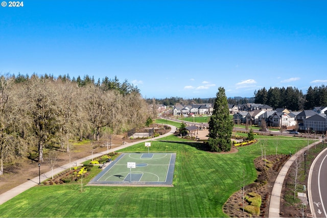 view of community featuring a lawn and basketball hoop