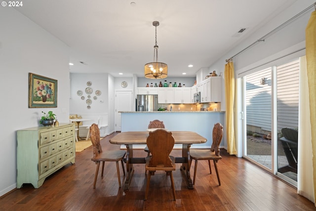 dining area featuring dark hardwood / wood-style flooring and an inviting chandelier