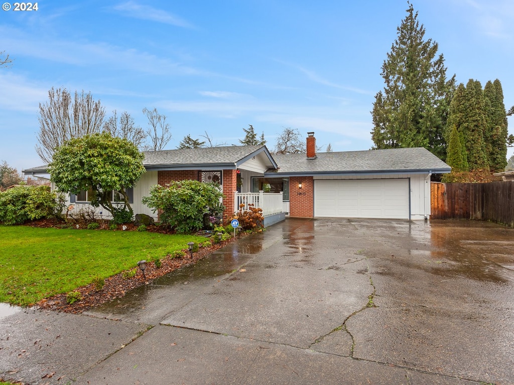 ranch-style house with a garage and a front lawn