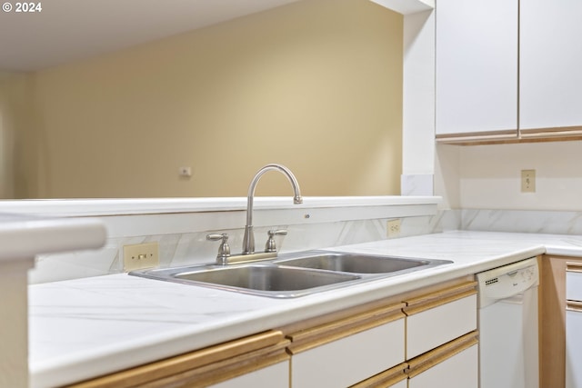 kitchen featuring sink, white cabinets, and white dishwasher