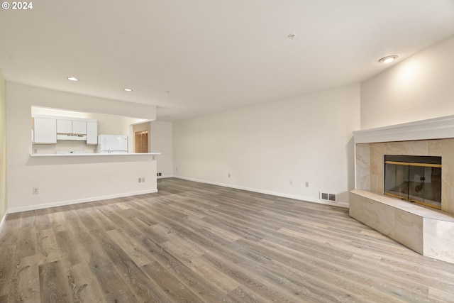 unfurnished living room featuring a fireplace and light wood-type flooring