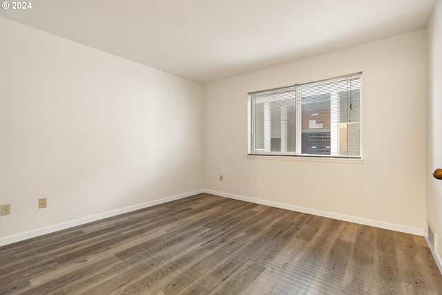 unfurnished room with dark hardwood / wood-style flooring