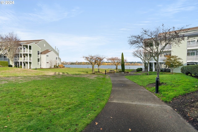 view of home's community featuring a lawn and a water view