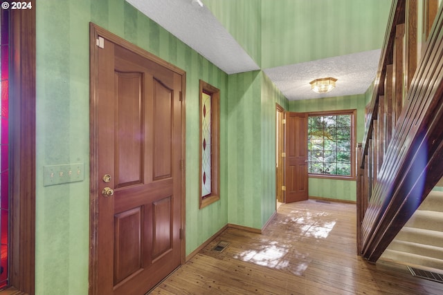 entrance foyer featuring a textured ceiling and light wood-type flooring