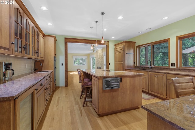 kitchen featuring a center island, hanging light fixtures, plenty of natural light, and light wood-type flooring