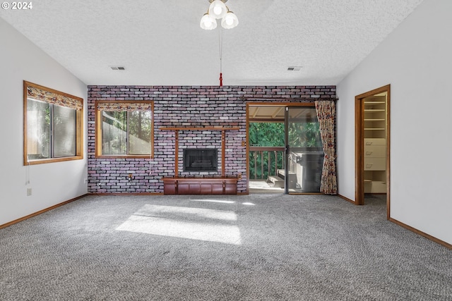 unfurnished living room with a textured ceiling, a healthy amount of sunlight, carpet, and vaulted ceiling