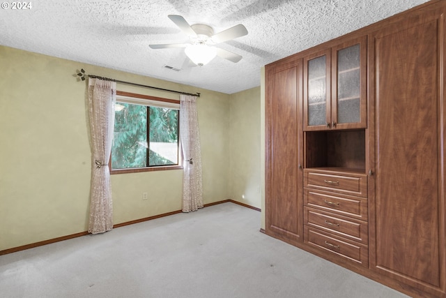 interior space with a textured ceiling and ceiling fan