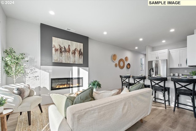 living room featuring a large fireplace and light wood-type flooring