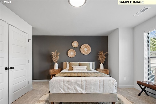 bedroom with light carpet and a closet