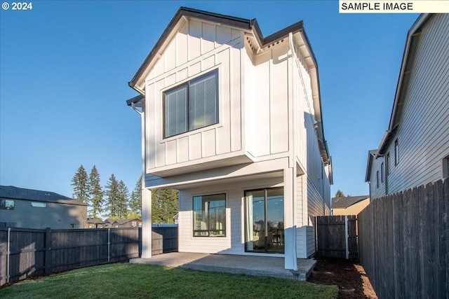 rear view of house featuring a patio area and a yard