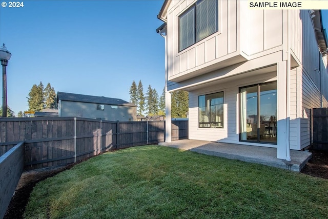 back of house with a patio area and a yard