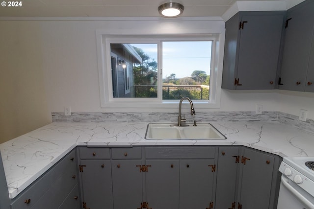 kitchen featuring a sink, gray cabinets, and white range oven