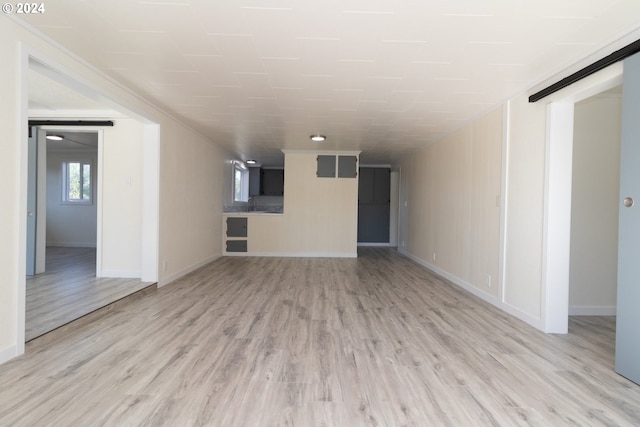 spare room with baseboards and light wood finished floors