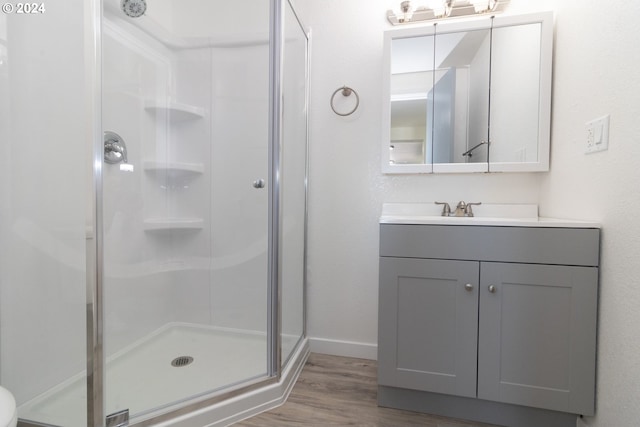 bathroom with vanity, hardwood / wood-style flooring, and a shower with shower door