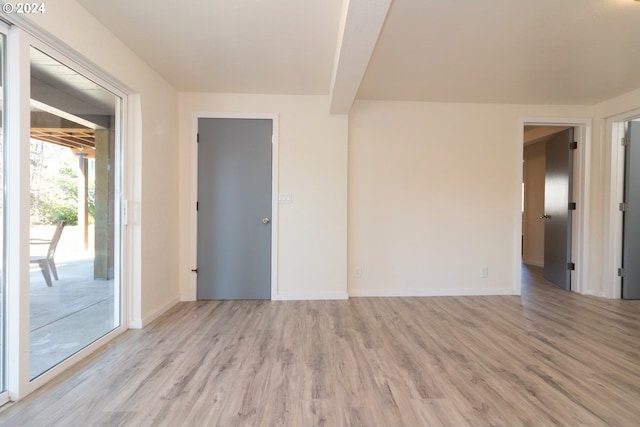 spare room featuring light wood-style flooring and baseboards