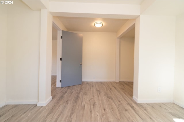 empty room with light wood finished floors and baseboards