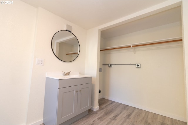 bathroom with baseboards, vanity, and wood finished floors