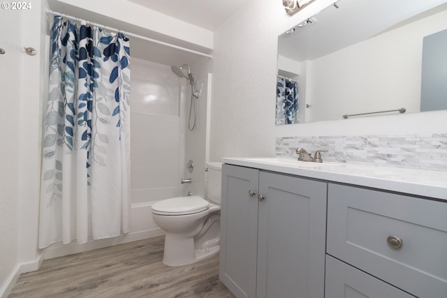 full bathroom featuring backsplash, vanity, shower / tub combo with curtain, hardwood / wood-style floors, and toilet