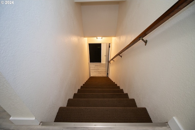 stairway featuring a textured wall