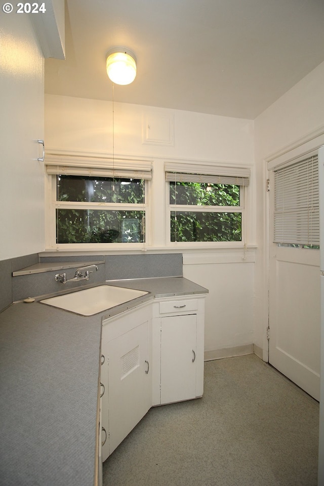 1805 NE 8th Ave, Portland, OR 97212 - kitchen with a sink, white cabinets, light countertops, and baseboards
