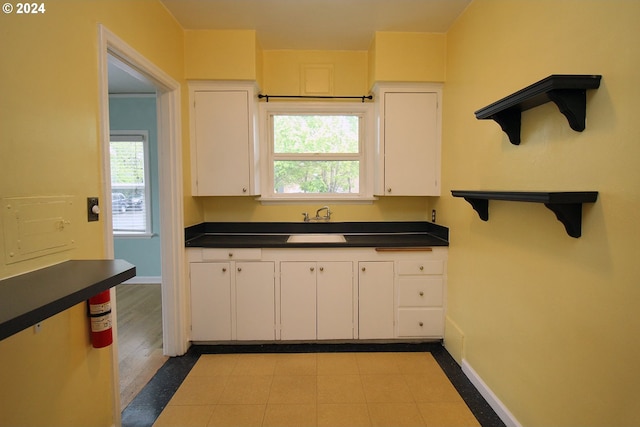 1805 NE 8th Ave, Portland, OR 97212 - kitchen with dark countertops, white cabinets, baseboards, and light tile patterned flooring
