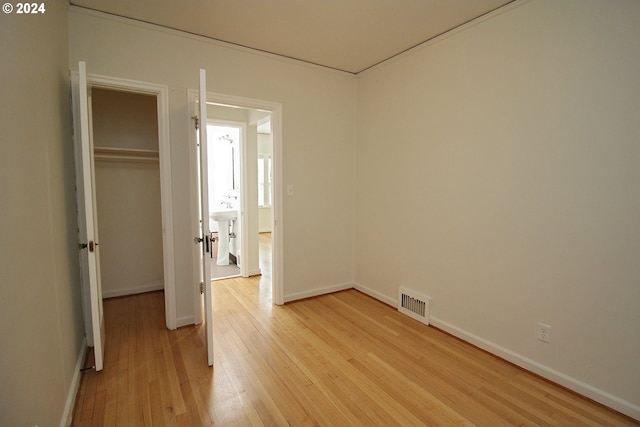 unfurnished bedroom with sink, light hardwood / wood-style floors, and a closet