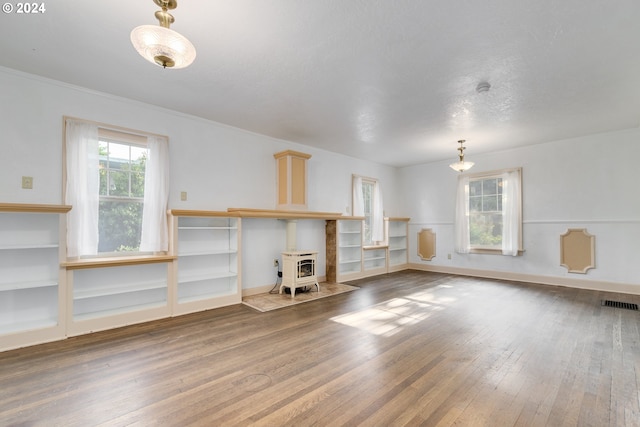170 N Jefferson St, Eugene, OR 97402 - unfurnished living room featuring a wood stove, hardwood / wood-style floors, and built in shelves