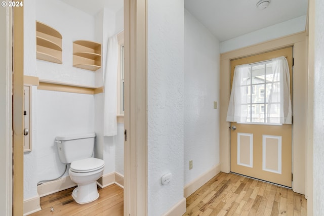 bathroom with hardwood / wood-style flooring and toilet