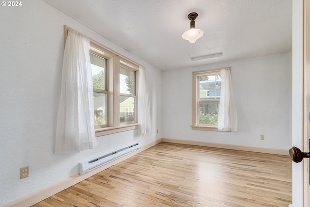 unfurnished room with light hardwood / wood-style flooring and a baseboard radiator