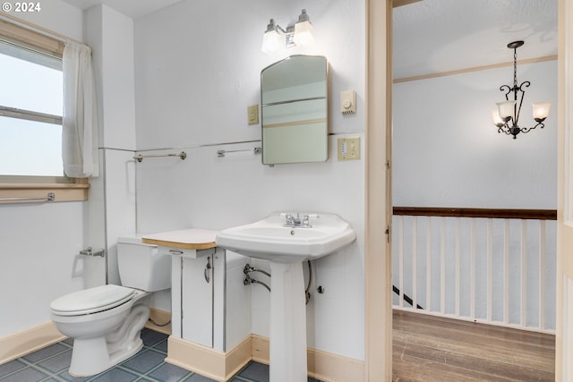 bathroom featuring sink, an inviting chandelier, and toilet