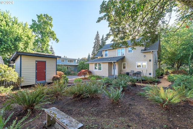 back of property with a storage shed