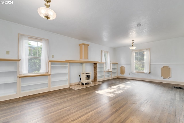 unfurnished living room featuring hardwood / wood-style flooring and a wood stove