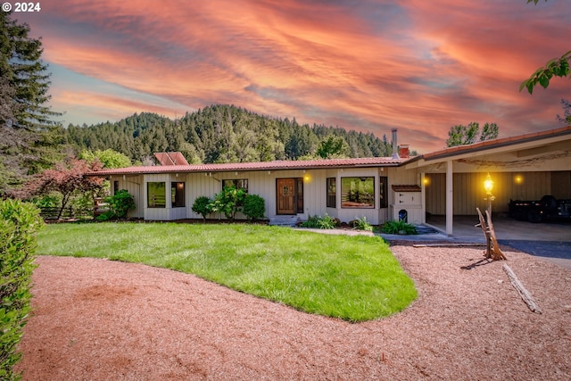 ranch-style house featuring a yard and a carport