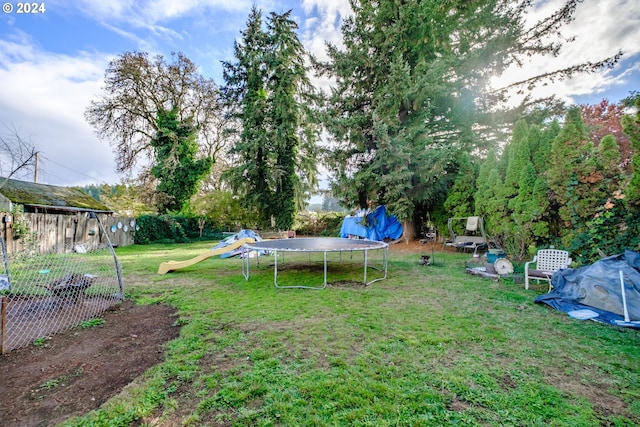 view of yard with a playground and a trampoline