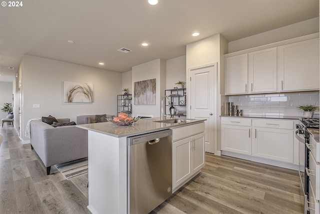 kitchen featuring white cabinetry, stainless steel appliances, and a center island with sink