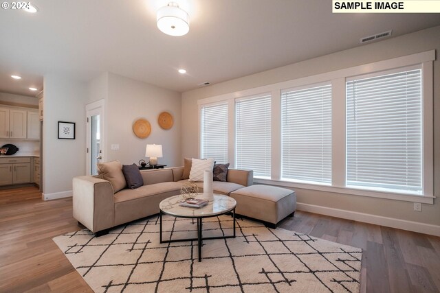 living room with a tile fireplace, hardwood / wood-style floors, and built in features