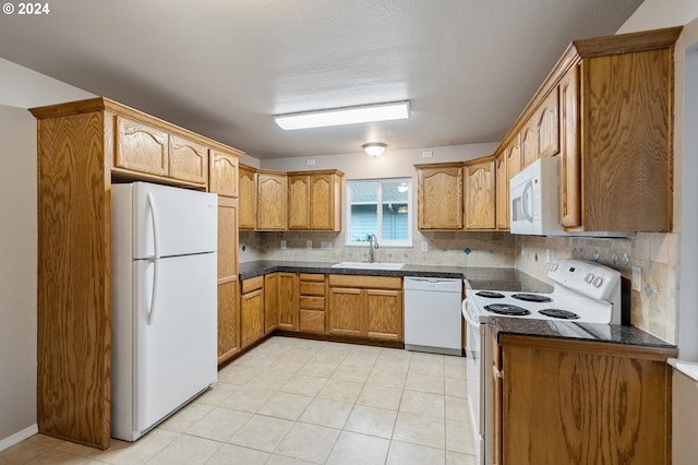 kitchen featuring sink, decorative backsplash, white appliances, and light tile patterned floors