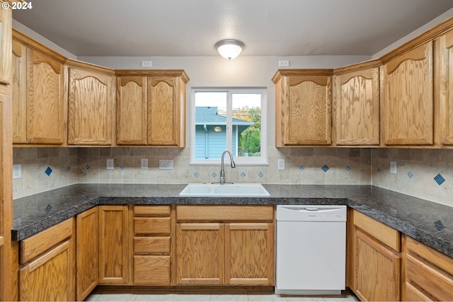 kitchen featuring tasteful backsplash, white dishwasher, and sink