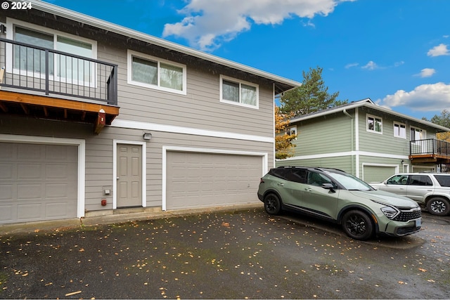 view of side of property featuring a balcony and a garage