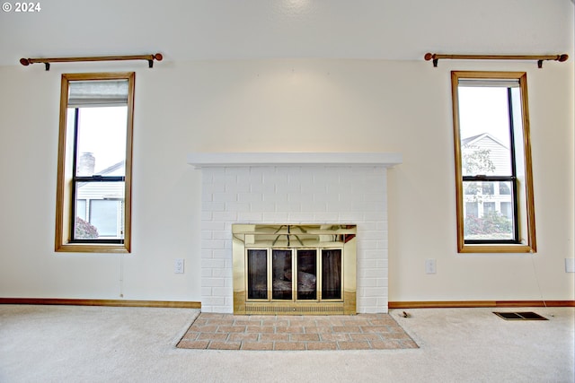 unfurnished living room featuring carpet flooring, plenty of natural light, and a fireplace