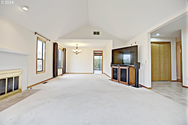 unfurnished living room with a notable chandelier, light colored carpet, a fireplace, and vaulted ceiling