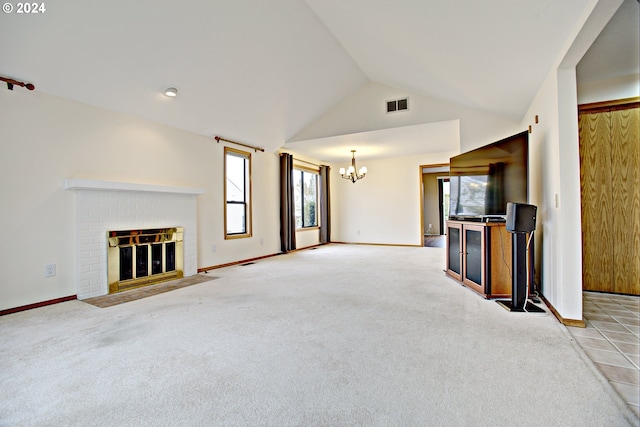 unfurnished living room featuring a notable chandelier, vaulted ceiling, a brick fireplace, and plenty of natural light