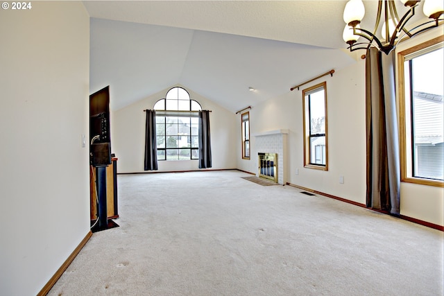 unfurnished living room featuring lofted ceiling, a brick fireplace, light colored carpet, and plenty of natural light