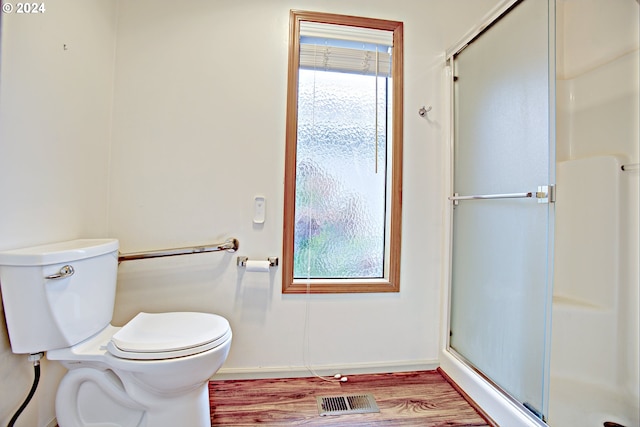 bathroom featuring toilet, an enclosed shower, and hardwood / wood-style floors