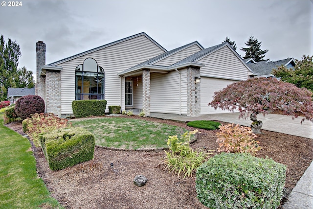 ranch-style home with a garage and a front lawn