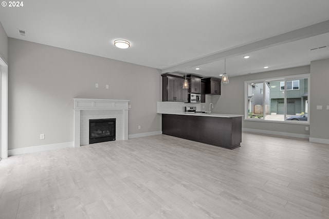 unfurnished living room featuring light wood-type flooring and sink