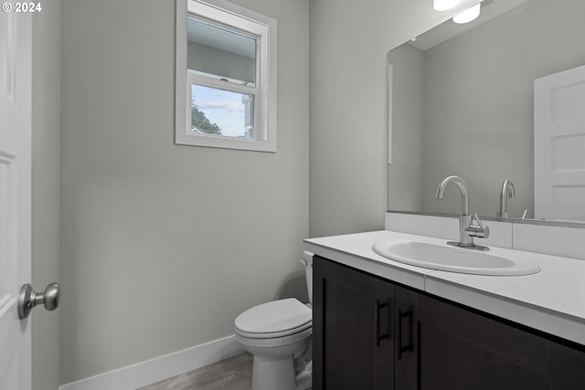 bathroom with vanity, toilet, and hardwood / wood-style flooring