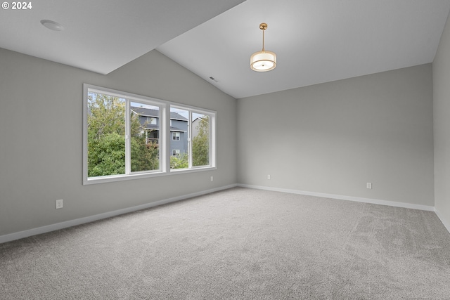 carpeted empty room featuring vaulted ceiling