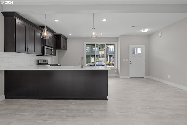 kitchen with pendant lighting, stainless steel appliances, and kitchen peninsula